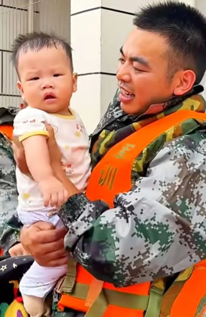 吴杰怀抱着从受灾区救出的婴儿
